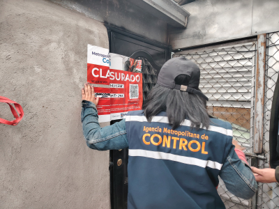 Yesenia Cabezas, líder zonal de AMC, colocando sello de clausura en labotario clandestino de licor adulterado.